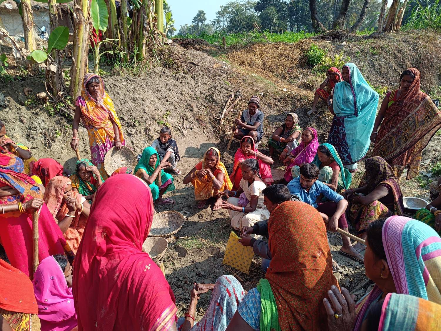 A ward-level meeting of women and men seated in a village in Bihar