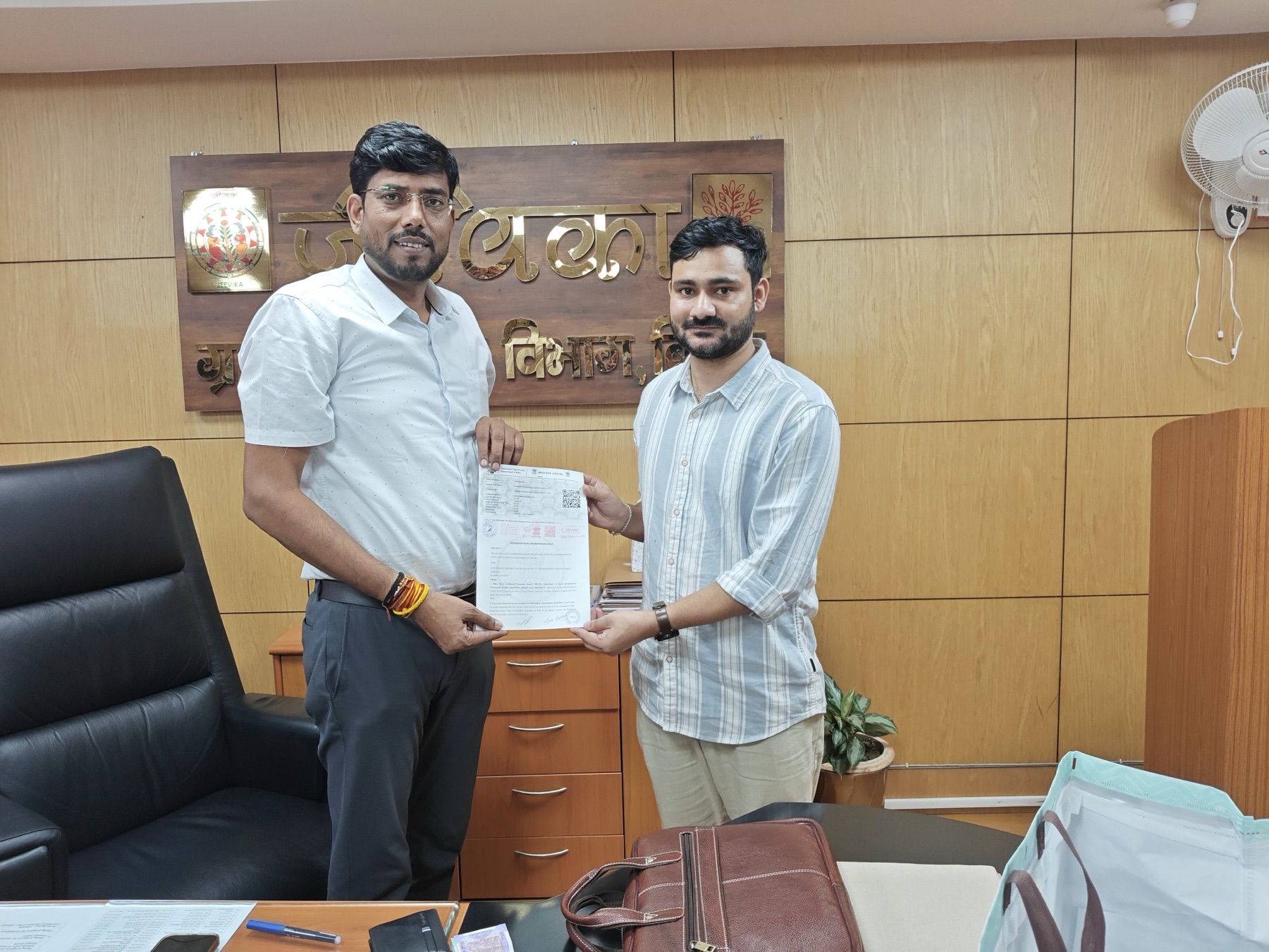 GRAMA team members exchanging a signed agreement