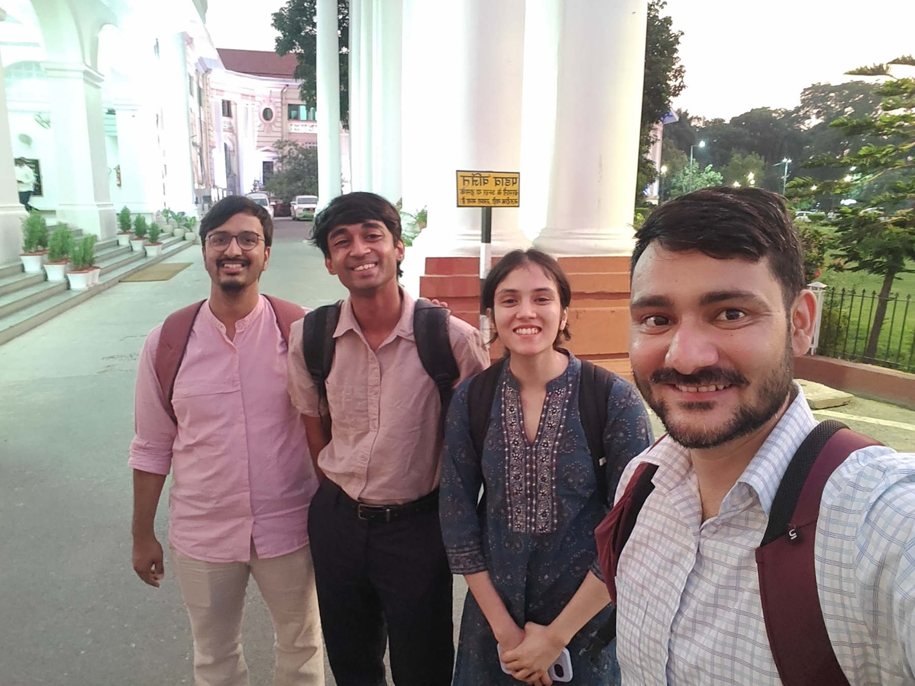 Four GRAMA team members outside a colonial-era building in Patna at dusk